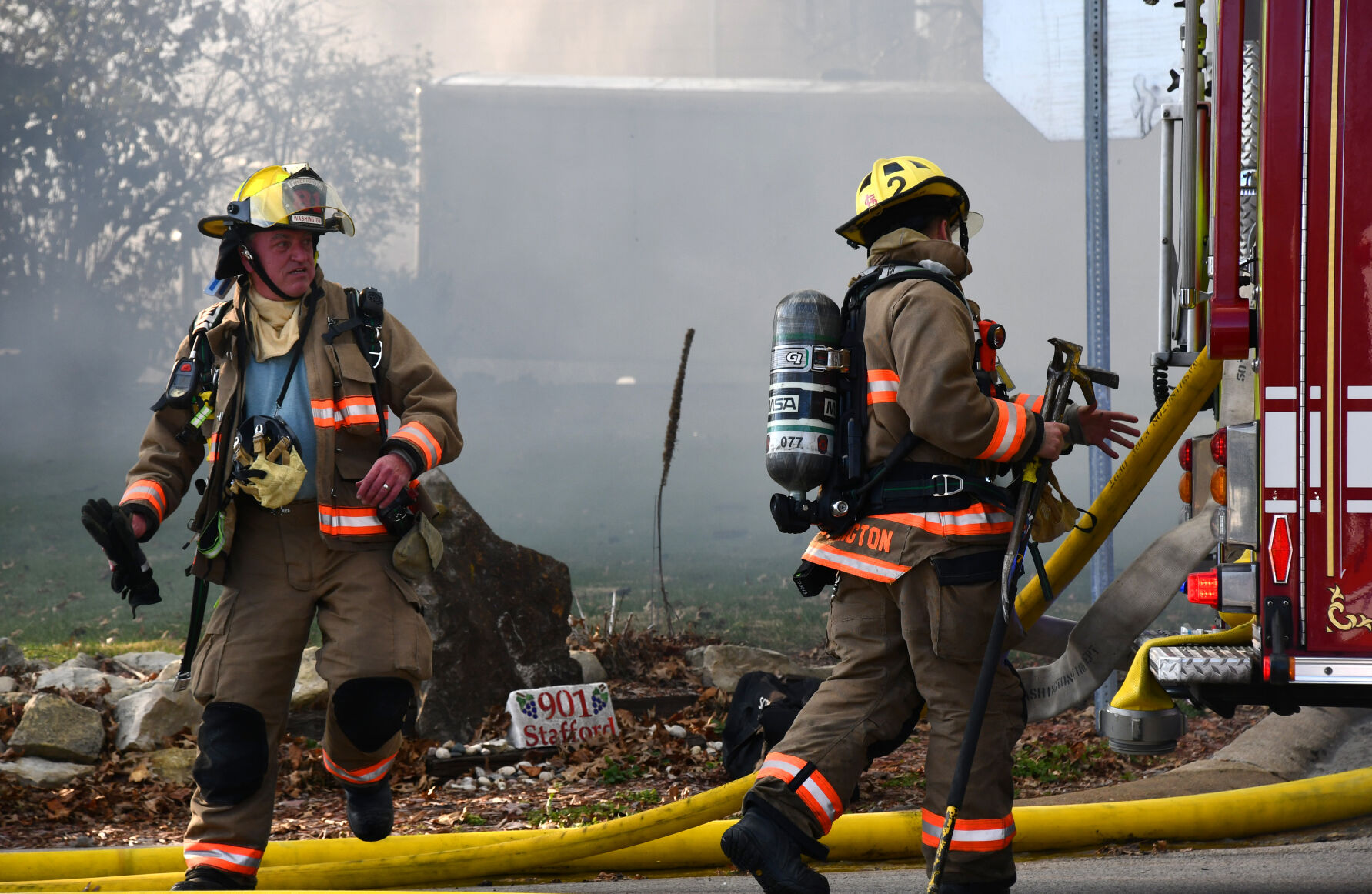 Firefighters rush toward the firetruck